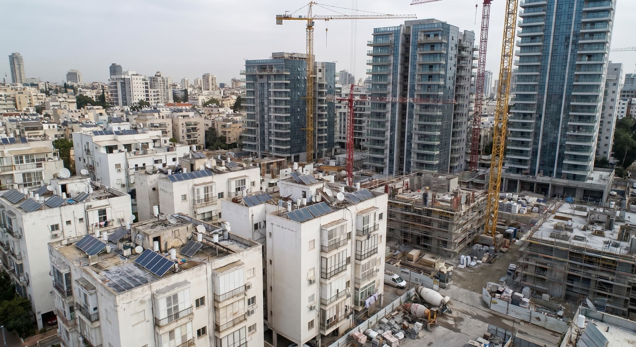 מבט מהאוויר על שכונה עירונית בהתחדשות עם מבנים ישנים ומגדלים חדשים — המחשה לתקדים מע"מ בהתחדשות עירונית