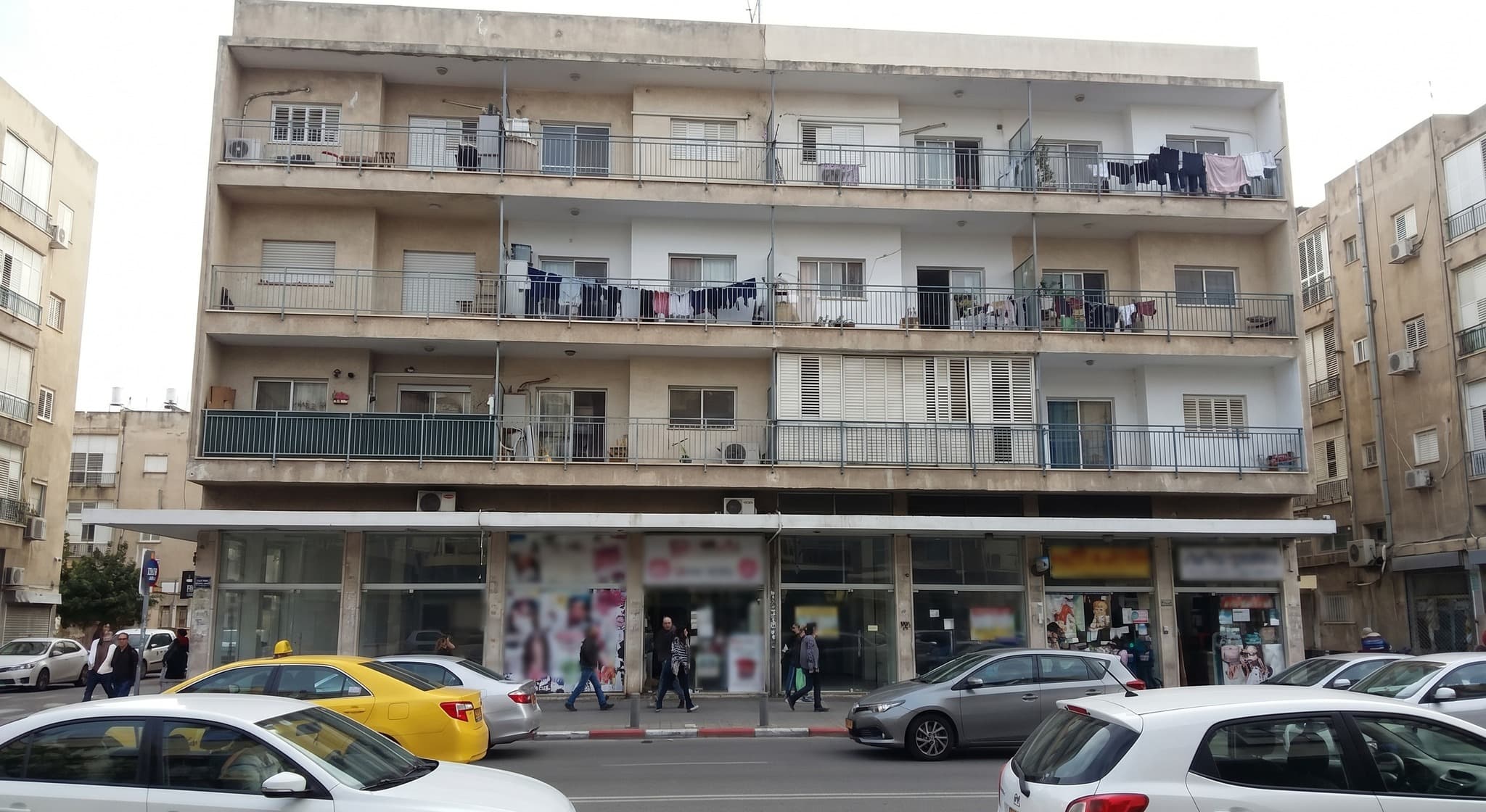 בניין מעורב עם חנויות בקומת הקרקע ודירות מגורים מעליהן — המחשה לתקדים פטור ממע"מ במכירת דירות